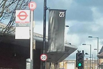 A black ‘IS’ banner is flying from a lamp post in Hackney