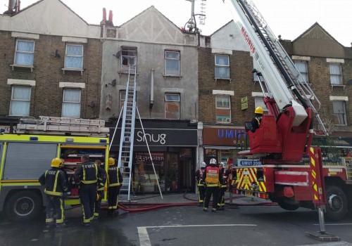 Woman arrested after rescue from burning flat in north London